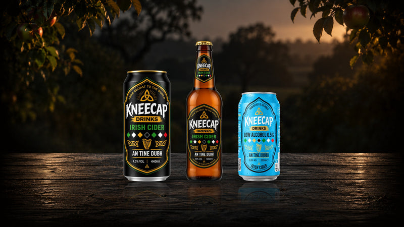 Kneecap Irish Cider can and bottle and the Low Alcohol Cider can on an orchard table at dusk