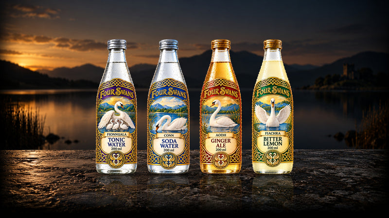 Four Swans Tonic Water, Soda Water, Ginger Ale and Bitter Lemon on a stone jetty by a lough at golden hour